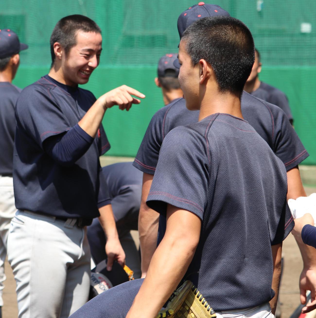 練習中、笑顔で盛り上げる横浜・度会（左）（撮影・古川真弥）