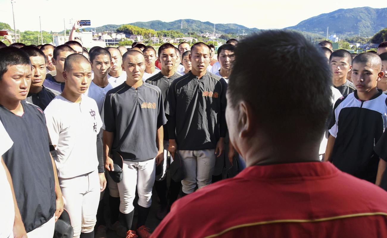 稙田監督（手前）から甲子園球場での交流試合開催決定を伝えられる創成館ナイン（共同）