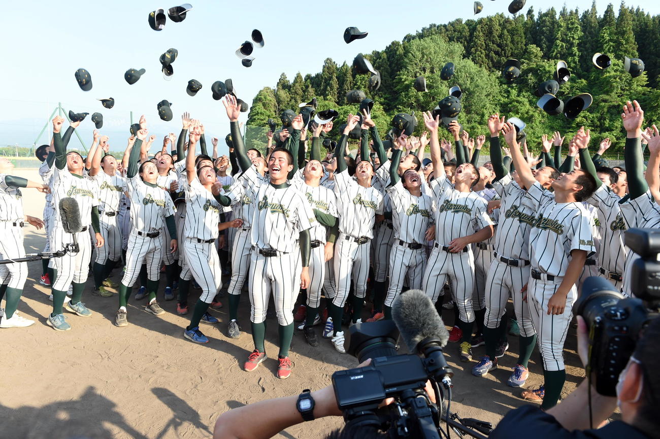 甲子園交流試合出場が決まり帽子を高々と上げる鶴岡東ナイン。中央手前は鈴木主将（撮影・山田愛斗）