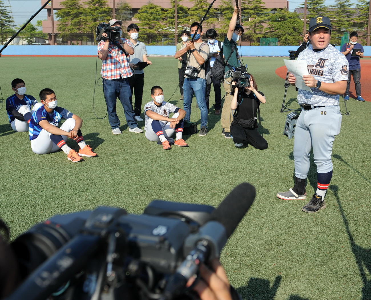 仙台育英の須江監督（右）は田中主将（中央）ら選手たちに甲子園交流試合に招待されたことを伝える