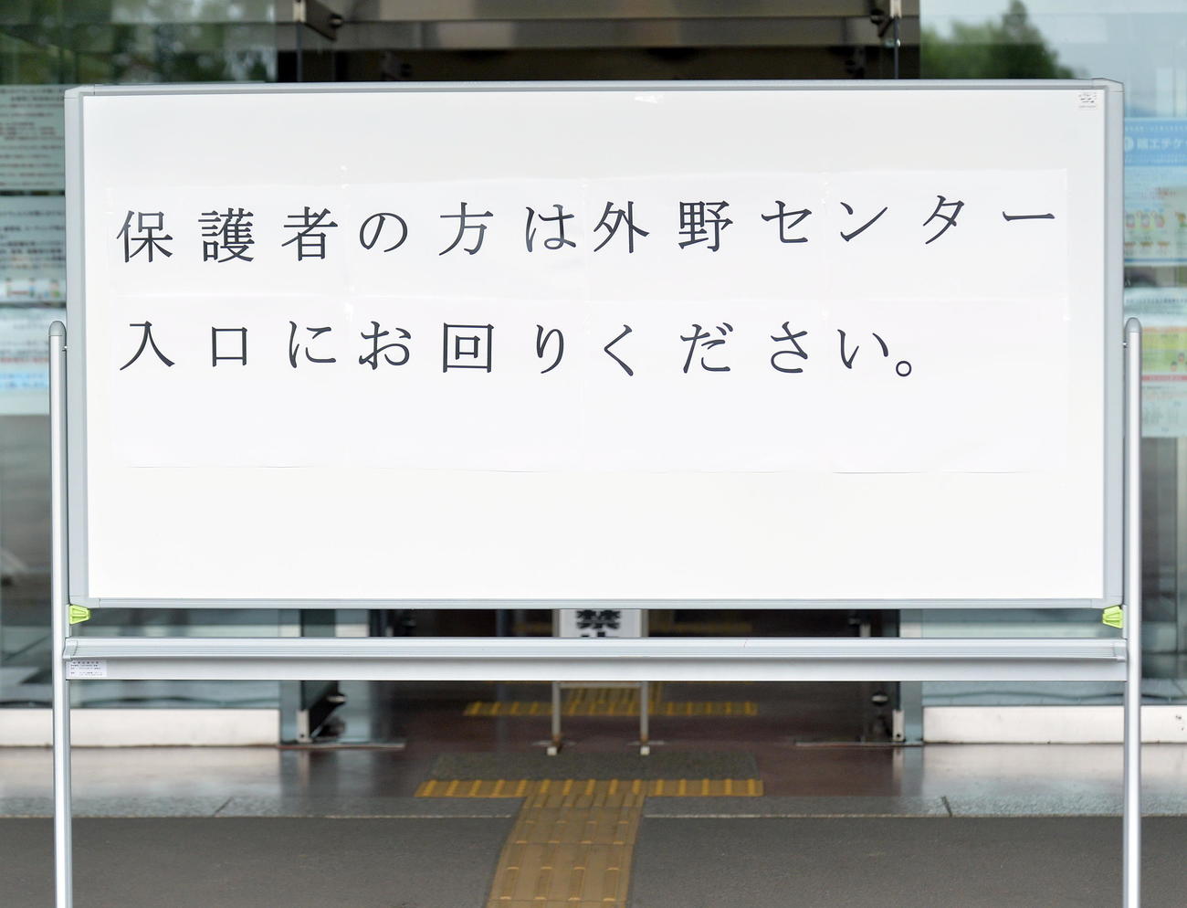 正面玄関に設置された保護者を外野席に誘導する掲示板（撮影・鎌田直秀）