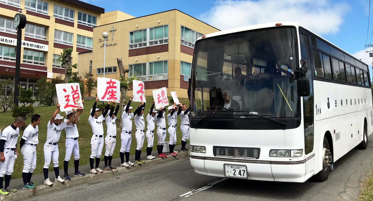 練習試合後、手作りのボードを掲げ白樺学園の選手が乗ったバスを送り出す北星学園大付の野球部員たち（撮影・永野高輔）