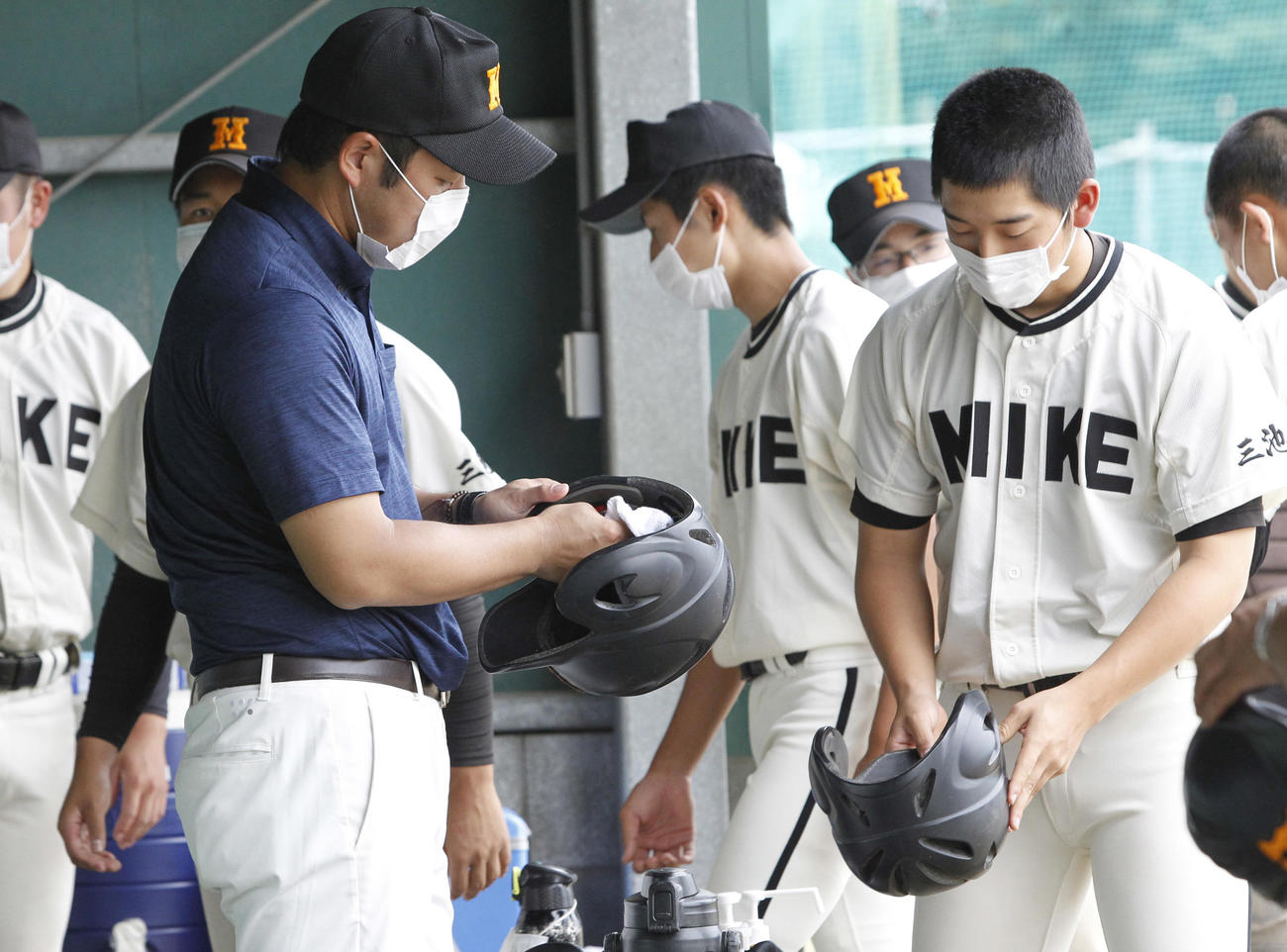 浮羽工対三池　イニングの合間にヘルメットを除菌する三池工ベンチ（撮影・菊川光一）