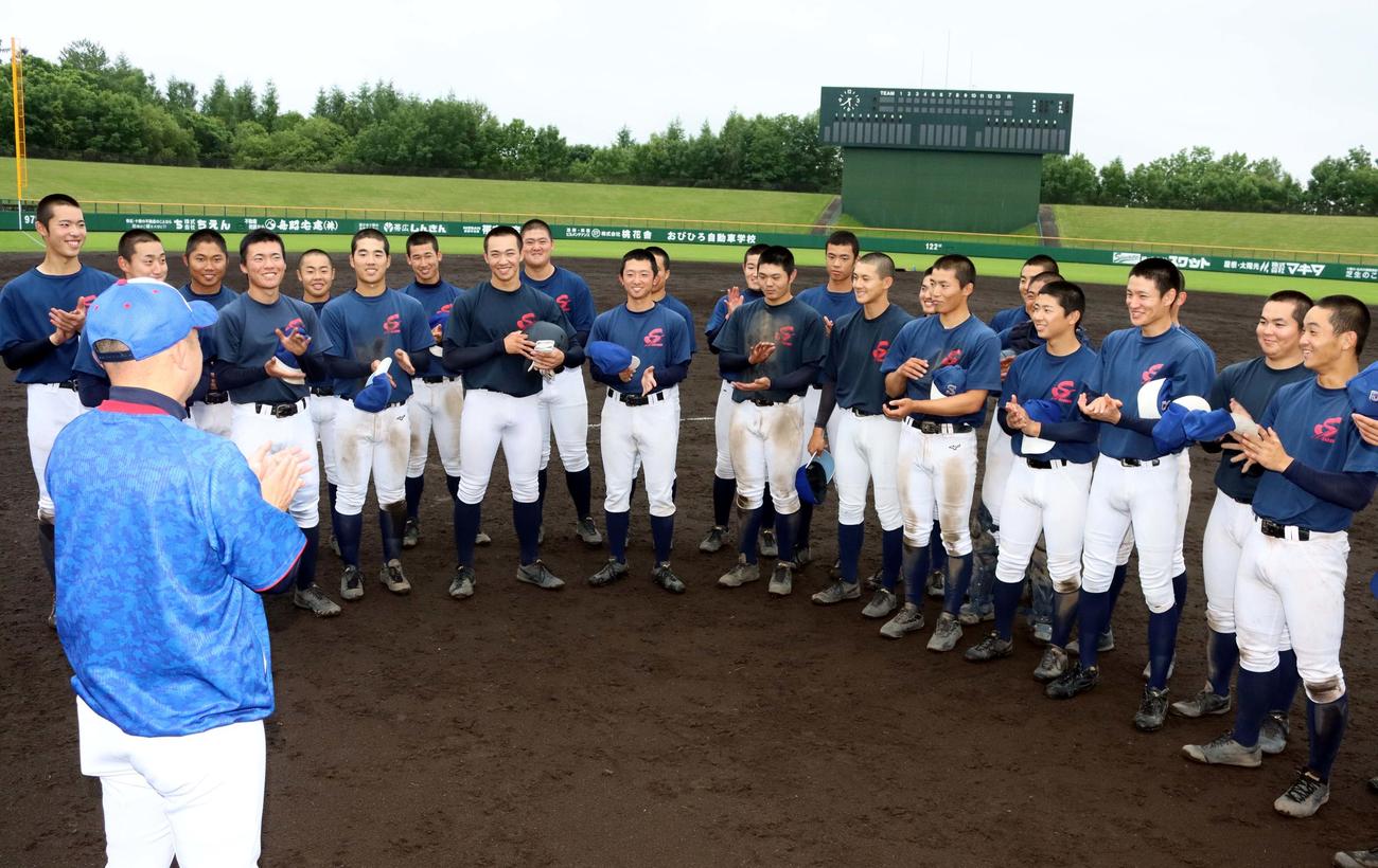 戸出監督（手前）から対戦相手の報告を受け笑顔を見せる白樺学園の選手たち（撮影・永野高輔）