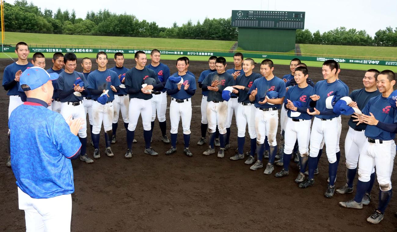 戸出監督（手前）から対戦相手の報告を受け笑顔を見せる白樺学園の選手たち（撮影・永野高輔）