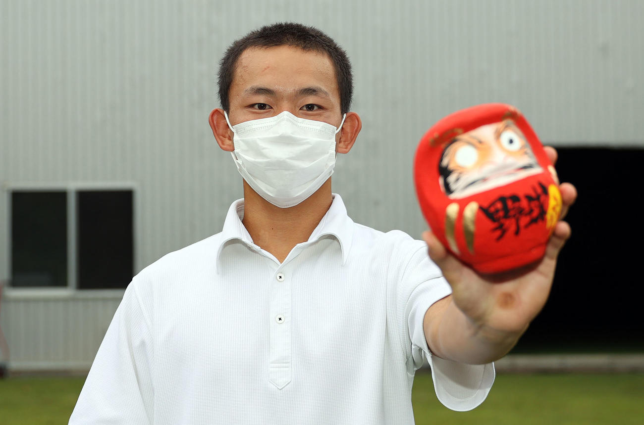 甲子園での対戦校が決まり、高崎名物のだるまを手に必勝を誓う高崎健康福祉大高崎・戸丸（撮影・大野祥一）