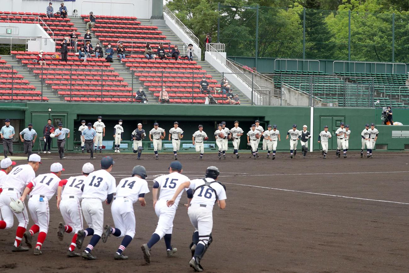 南北海道：渡島連合対函館水産　試合開始と同時に駆け出す函館水産ナインと渡島連合ナイン（左手前）（撮影・佐藤翔太）