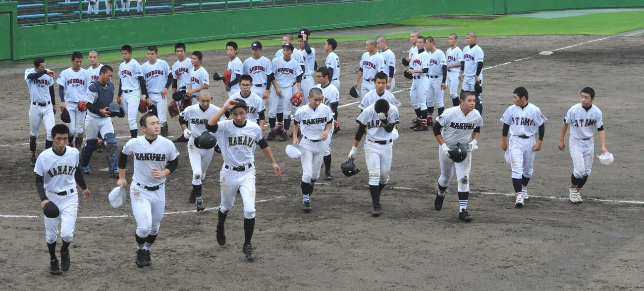 試合終了後、ベンチに引き揚げる3校連合の選手ら（手前）