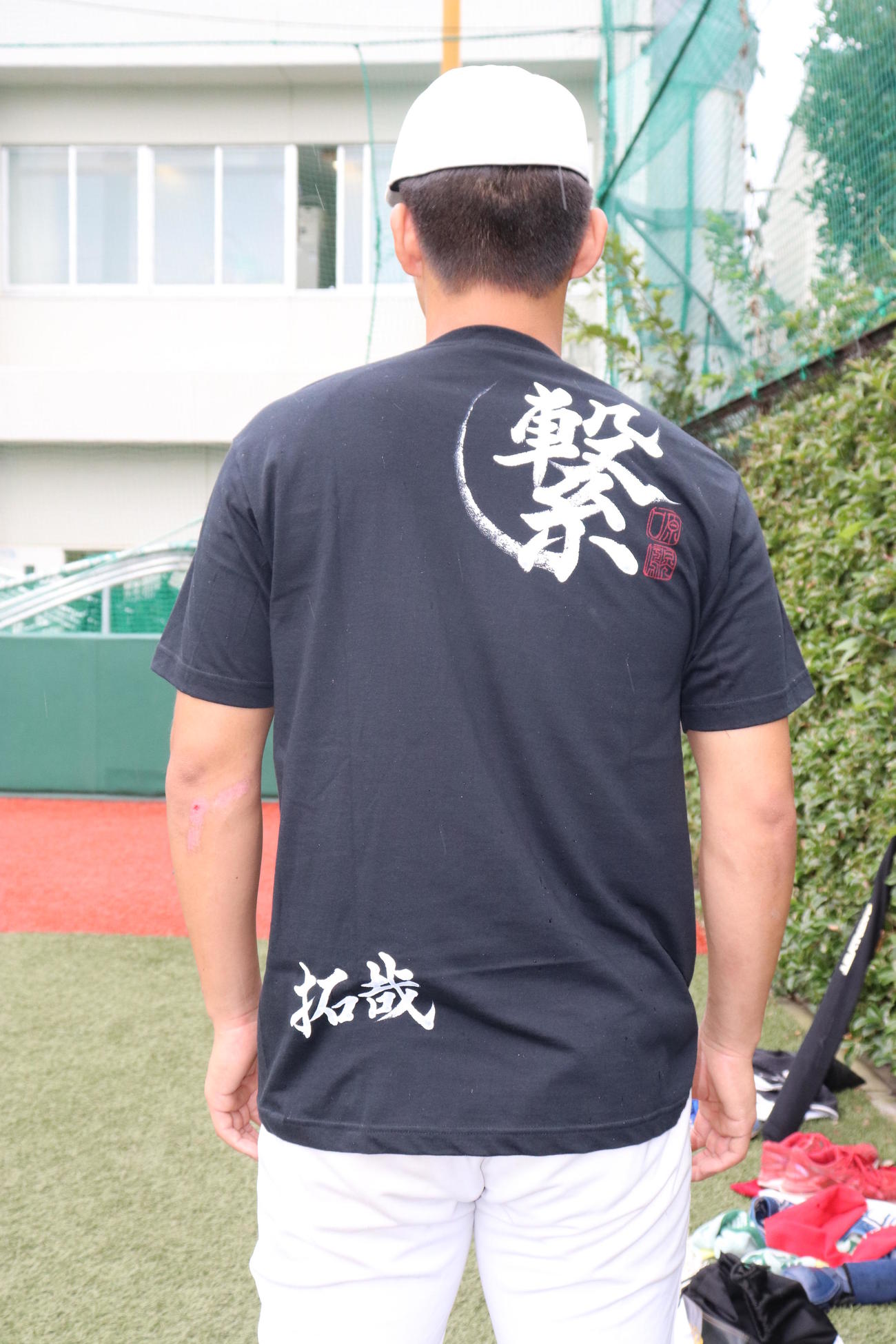 OBである阪神原口から贈られたTシャツを着る帝京・加田。裏には「繋」の文字と、各選手の名前が記されている（撮影・古川真弥）