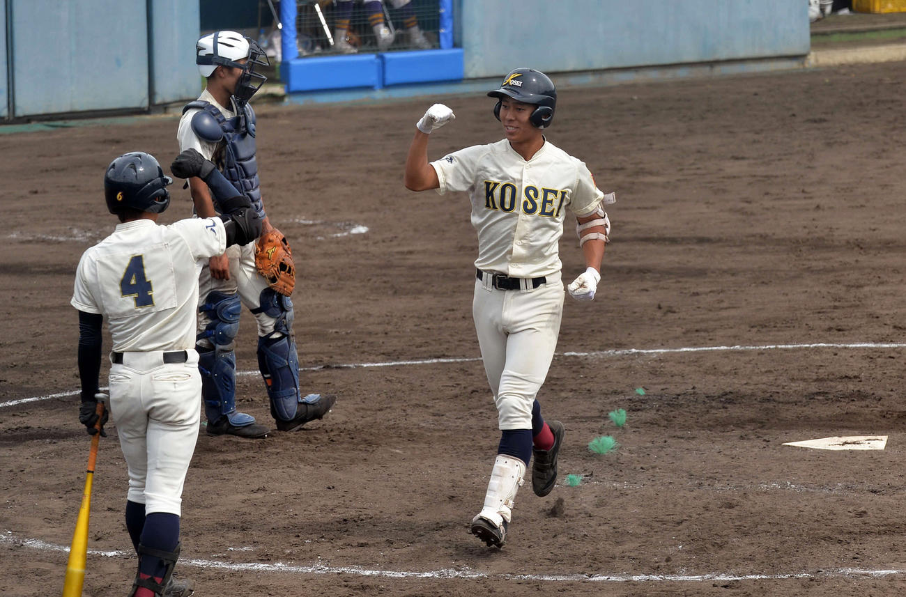 甲子園の土が使われたダイシンベースボールスタジアムで、代打本塁打を放ち生還する八戸学院光星・国武（右）（撮影・佐藤究）