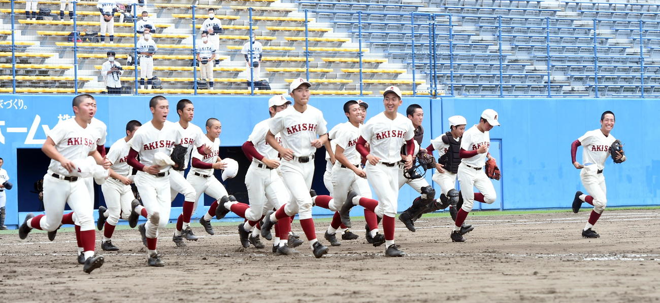 勝利の報告に応援席へ向かう秋田商ナイン