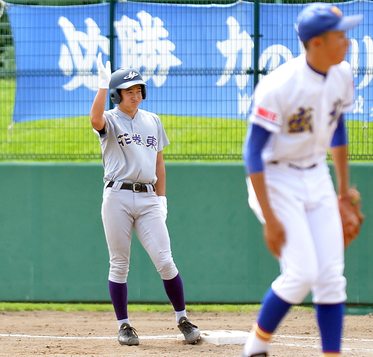 花巻東対盛岡北　2回表花巻東1死一、二塁、中前適時打を放ち、一塁塁上で仲間の声援に右手を小さく手を上げる安ケ平（撮影・鎌田直秀）