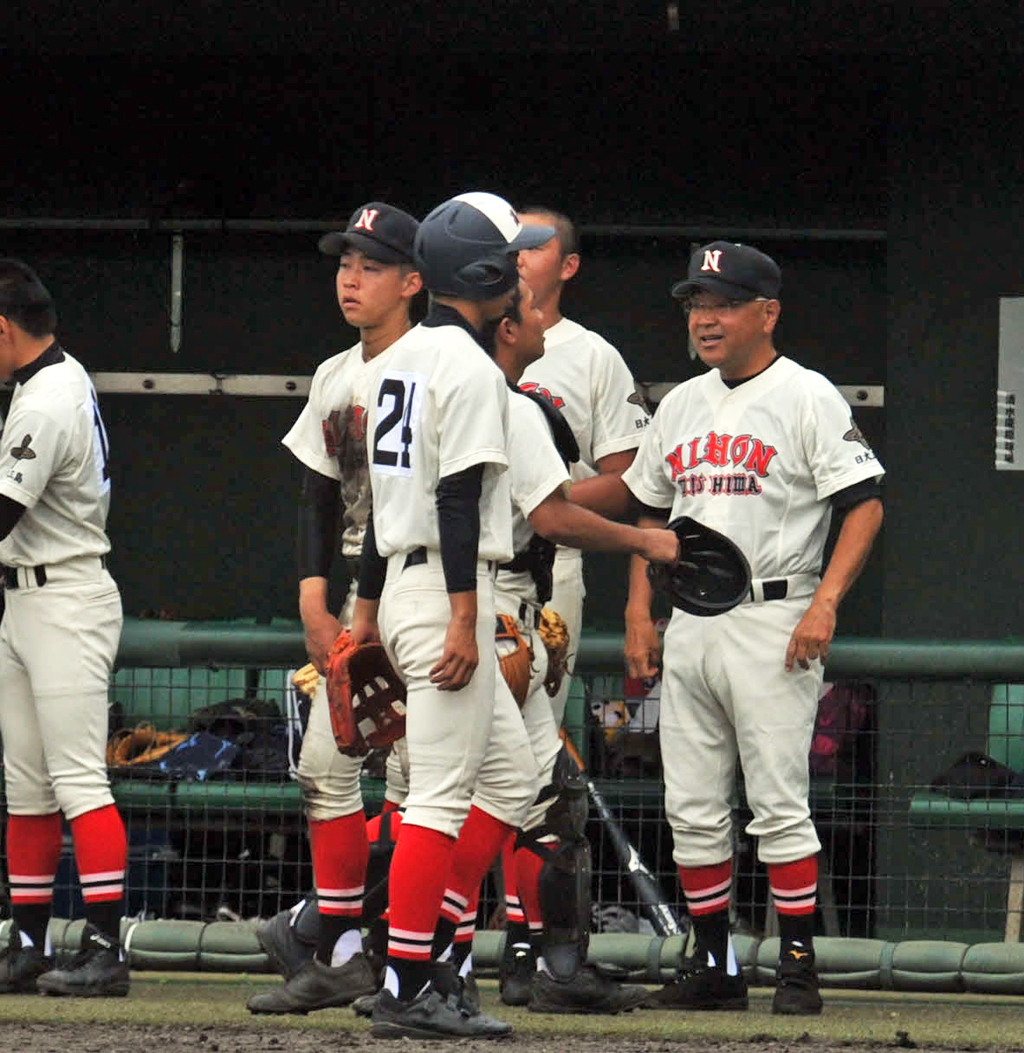 イニングの合間に選手たちへ声をかける日大三島・永田監督（右端）（撮影・古地真隆）