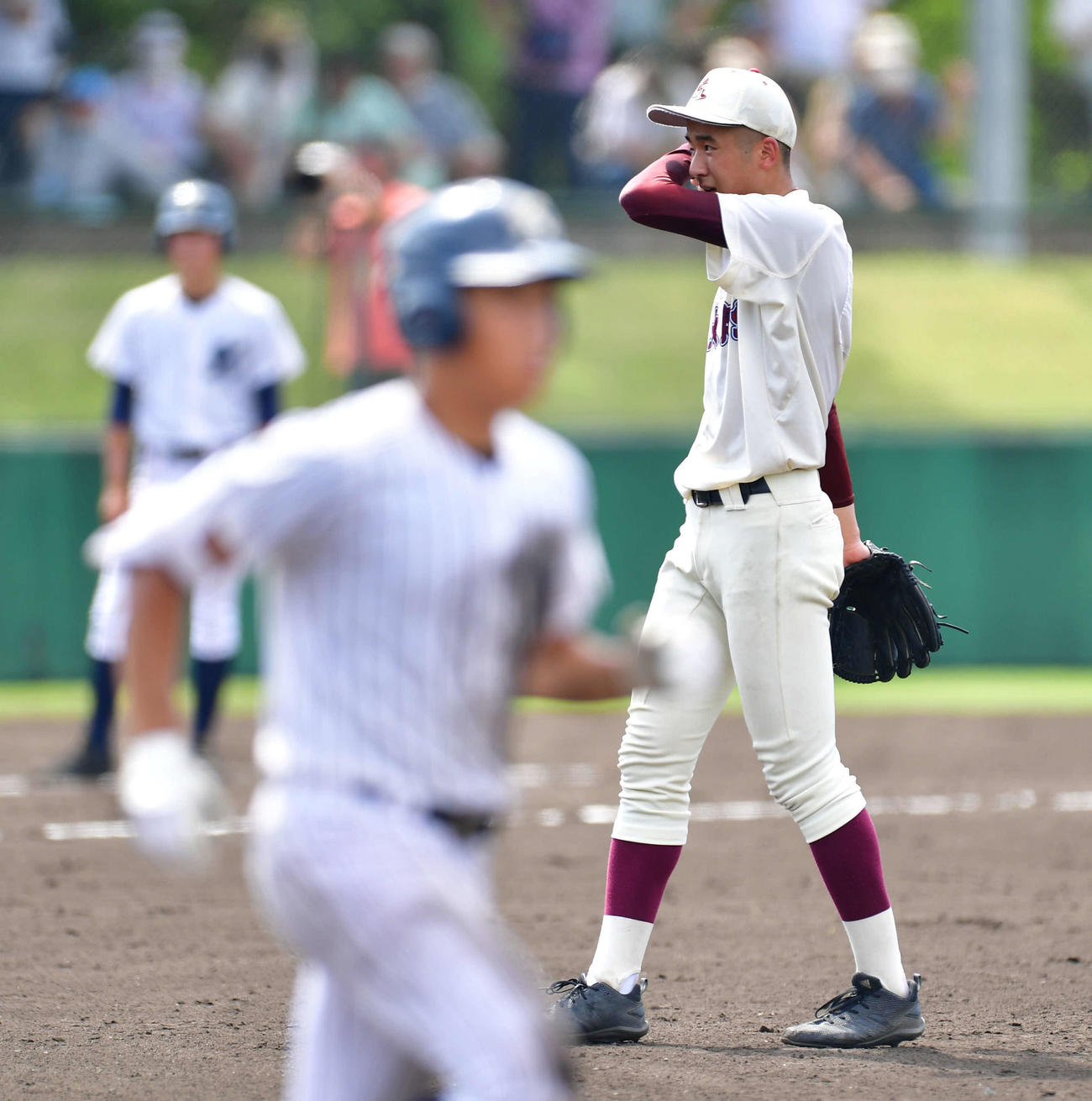 大阪偕星対近大泉州　3回表大阪偕星無死、岡本塊士（手前）に死球を当て、汗を拭う近大泉州・中尾純一朗（撮影・岩下翔太）
