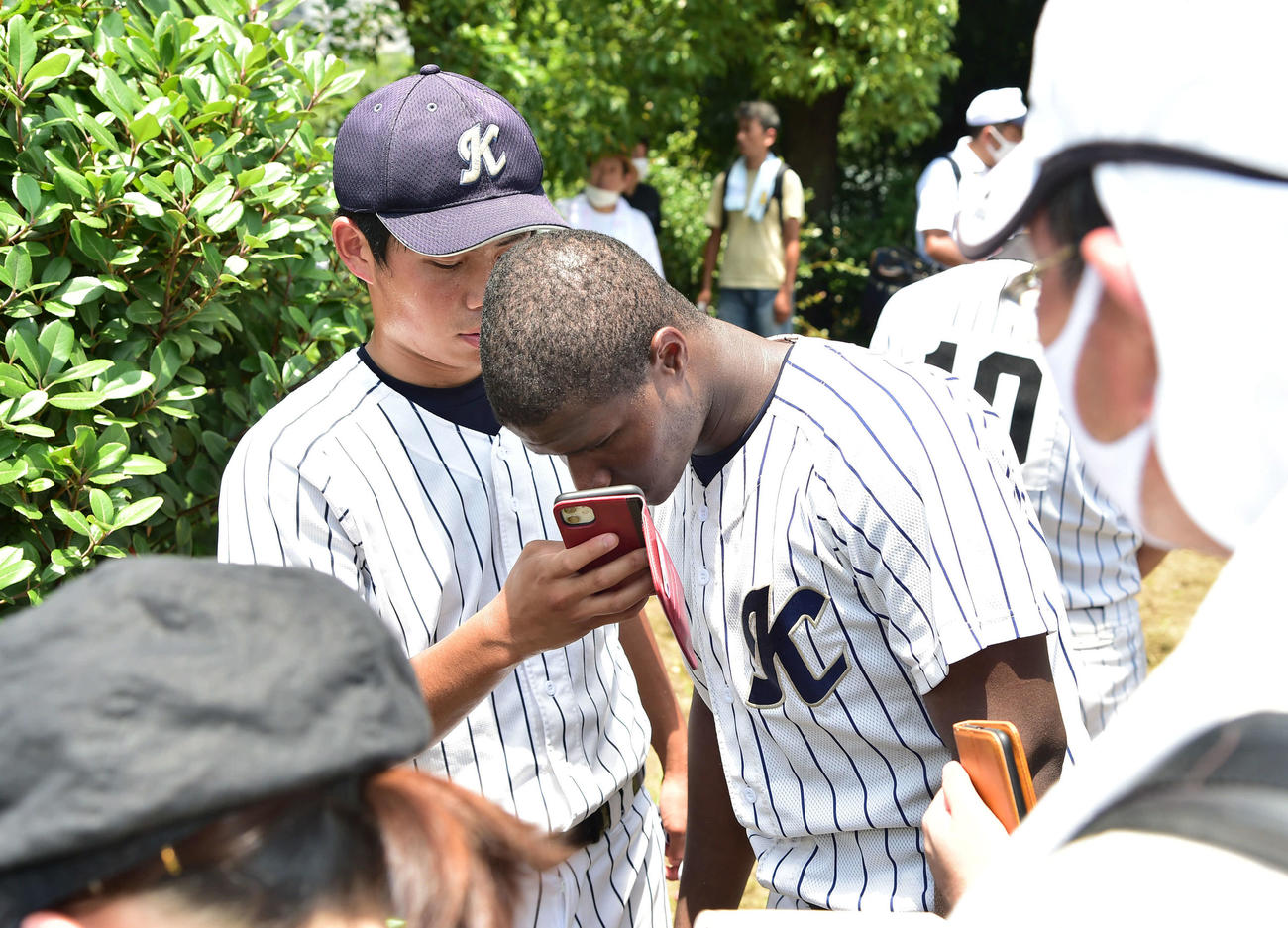 大阪偕星対近大泉州　試合後、スマートフォンの翻訳アプリを使って囲み取材を受ける大阪偕星のダビット・バチスタ・モレノ（撮影・岩下翔太）