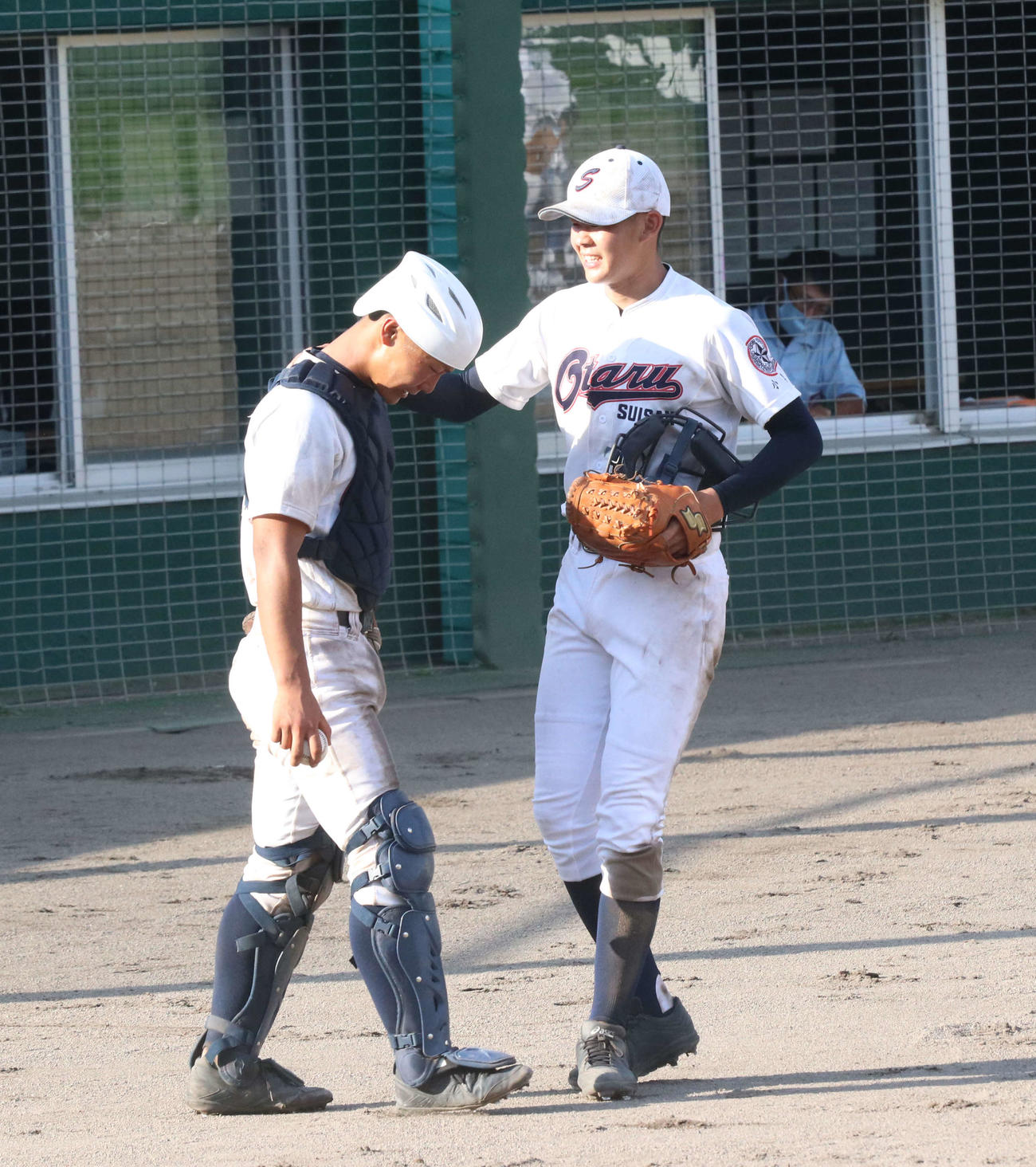 小樽水産対北照　タイブレーク11回裏北照1死満塁、暴投で試合に敗れた小樽水産先発寺沢（右）は女房役の岡本捕手をねぎら（撮影・浅水友輝）