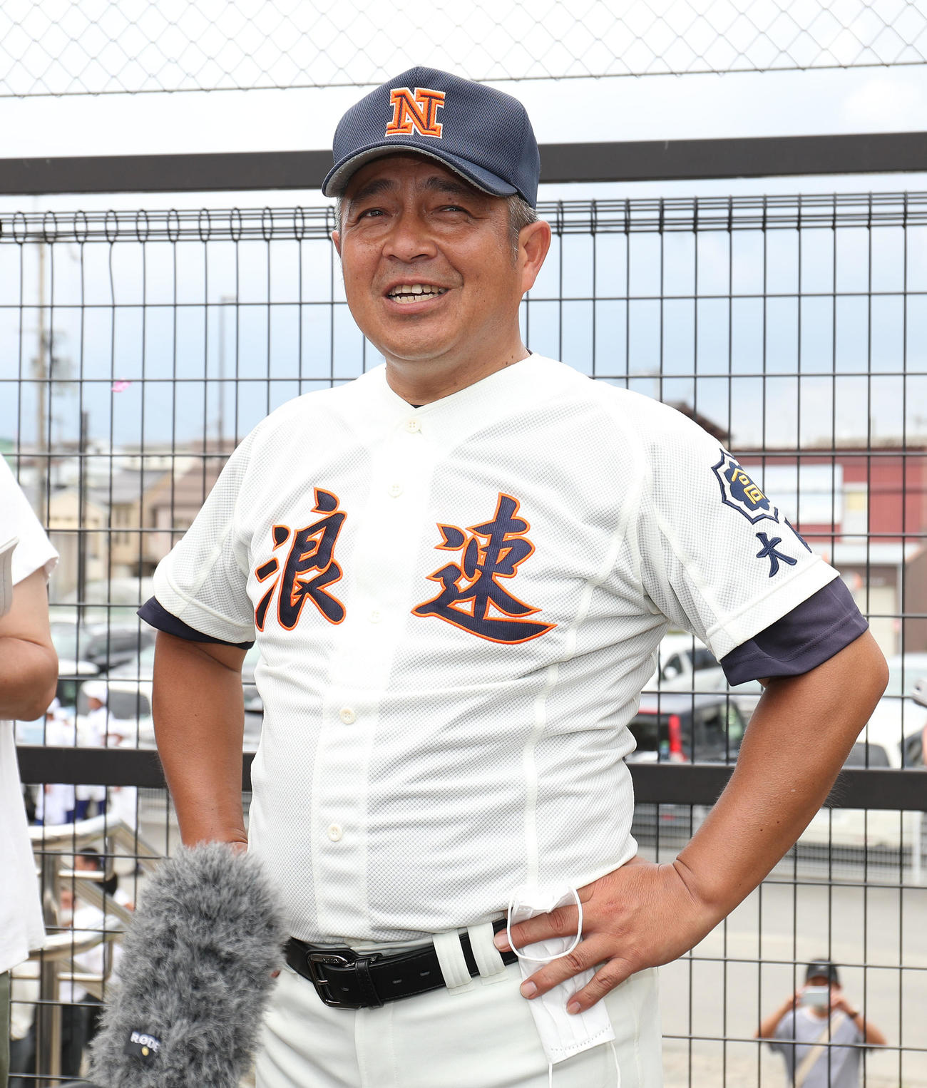 浪速対桃山学院　桃山学院に7回コールド勝ちして、公式戦初勝利を上げて囲み取材で笑顔を見せる浪速、遠山昭治監督（撮影・白石智彦）
