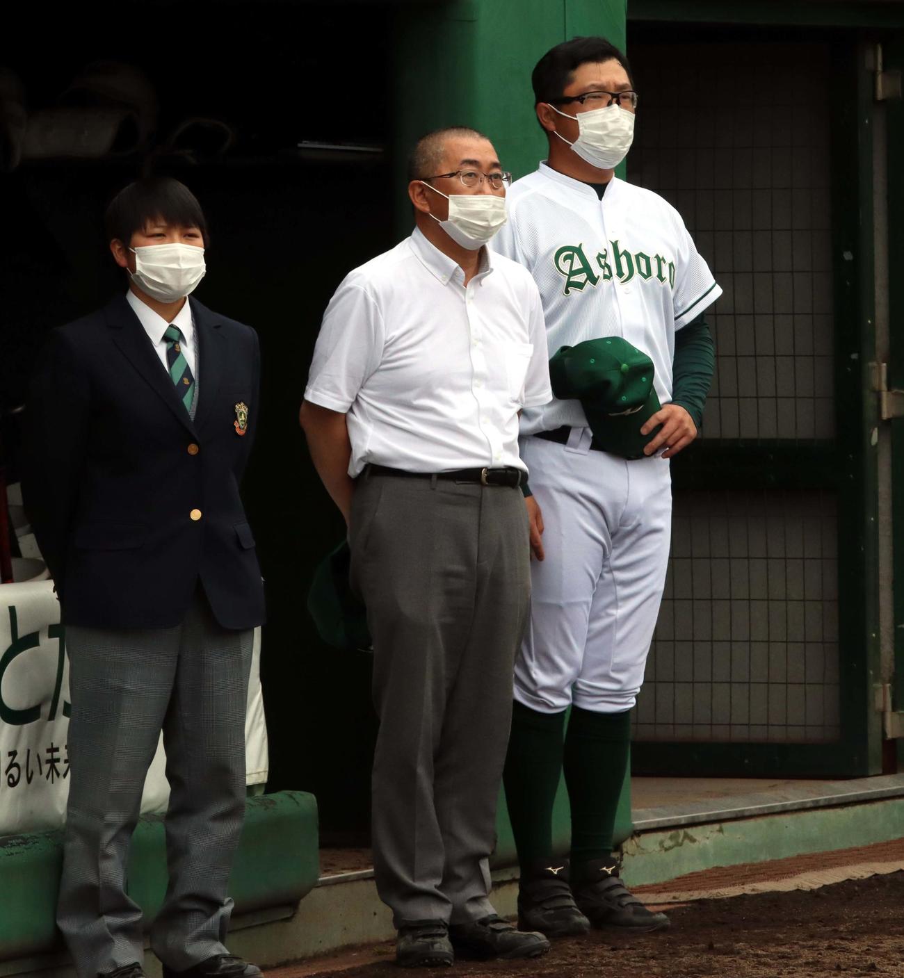 足寄対鹿追　ベンチ前で校歌を聞く元日本ハムの足寄・池田監督（右）（撮影・永野高輔）