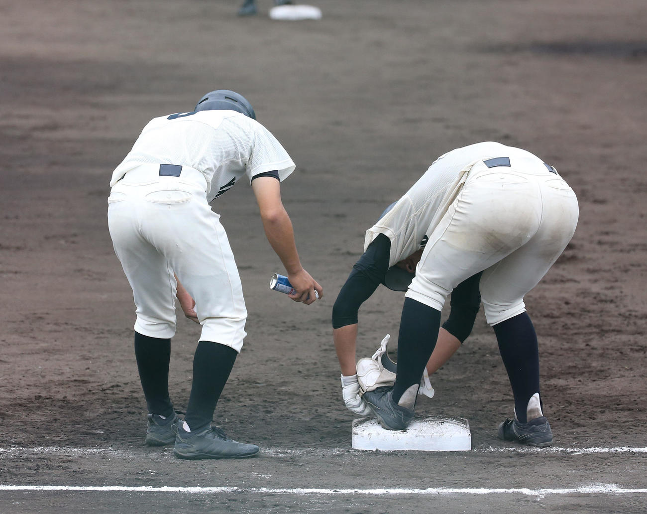 7回裏山本2死二、三塁、右手首に死球を受けて一塁でアイシングする松井翔馬（右）（撮影・白石智彦）