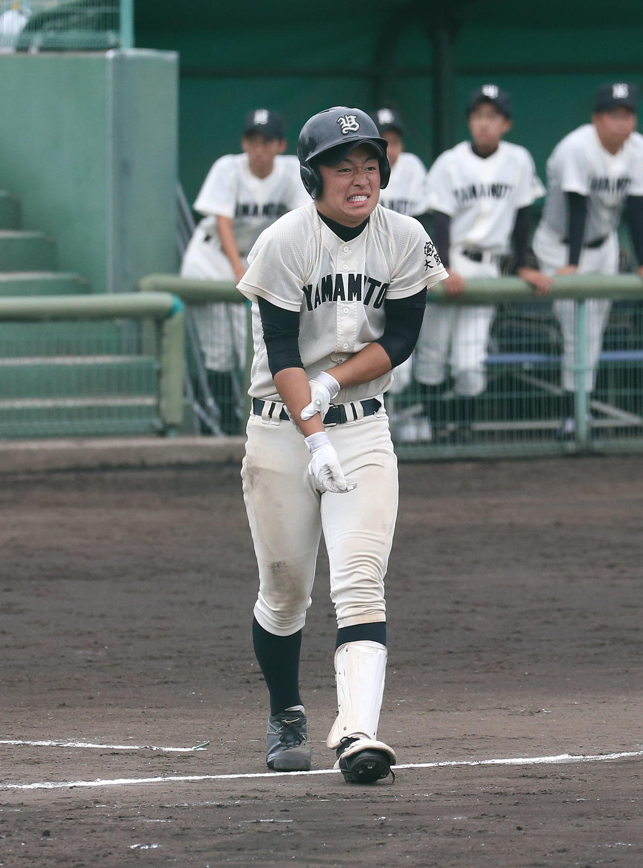 高石戦の7回、右手首に死球を受けて痛がる山本・松井翔馬（撮影・白石智彦）