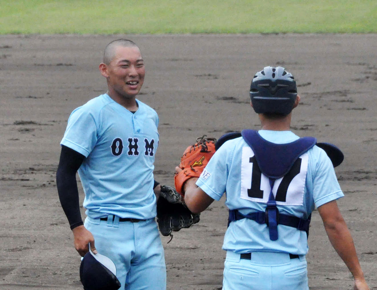 光泉カトリック戦で最後の打者を右飛に打ち取り笑顔を見せる近江・山田陽翔。右は更田龍騎（撮影・石橋隆雄）