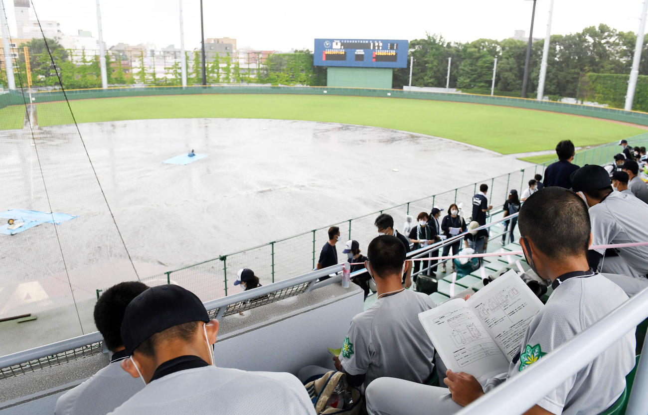 スタンドで勉強をしながら雨がやむのを待つ小山台ナイン（撮影・横山健太）