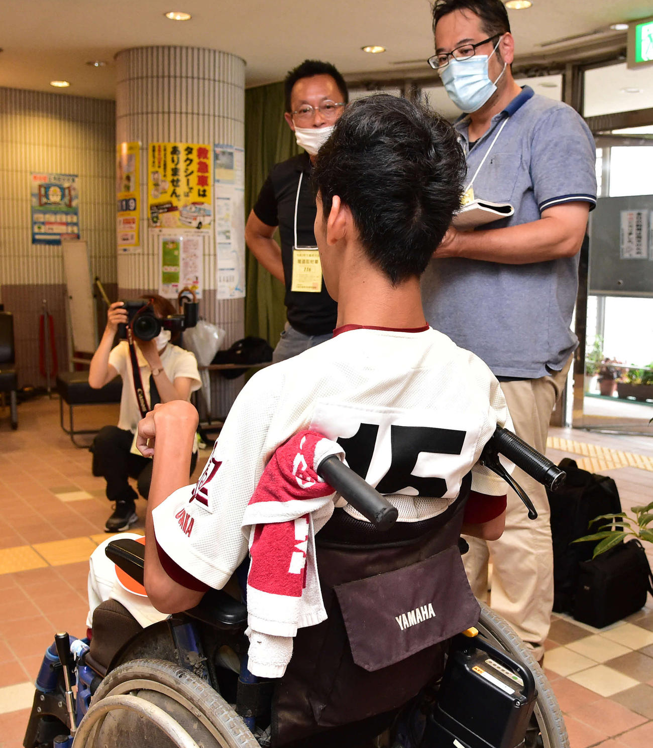 渋谷・中川慶人は試合が降雨で3回ノーゲームとなり、背番号15番をのぞかせながら取材を受ける（撮影・岩下翔太）