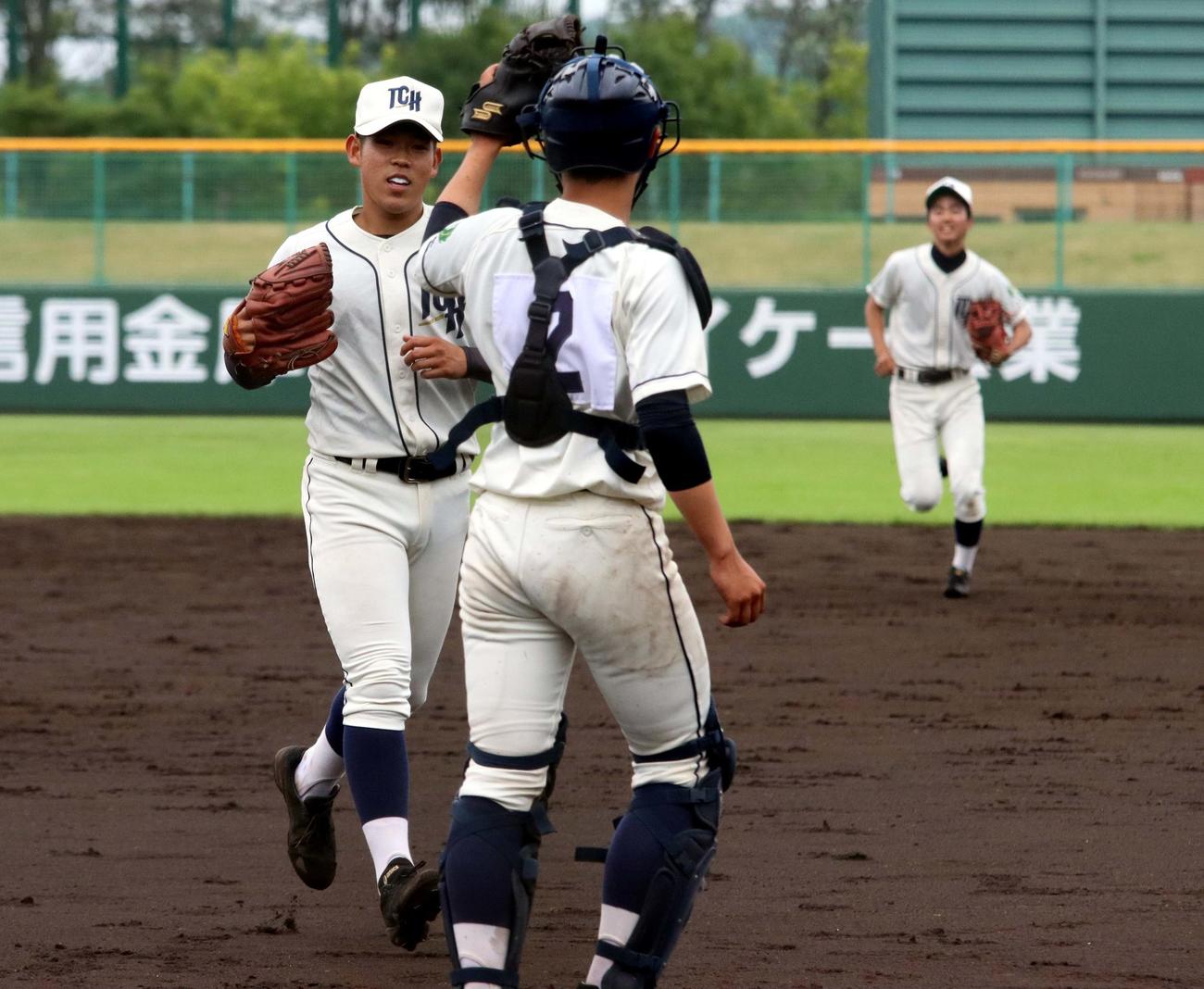 苫小牧工対苫小牧中央　完封勝利で南北海道大会出場を決めた苫小牧中央のエース根本（左）は笹原捕手とグラブタッチして喜ぶ（撮影・永野高輔）