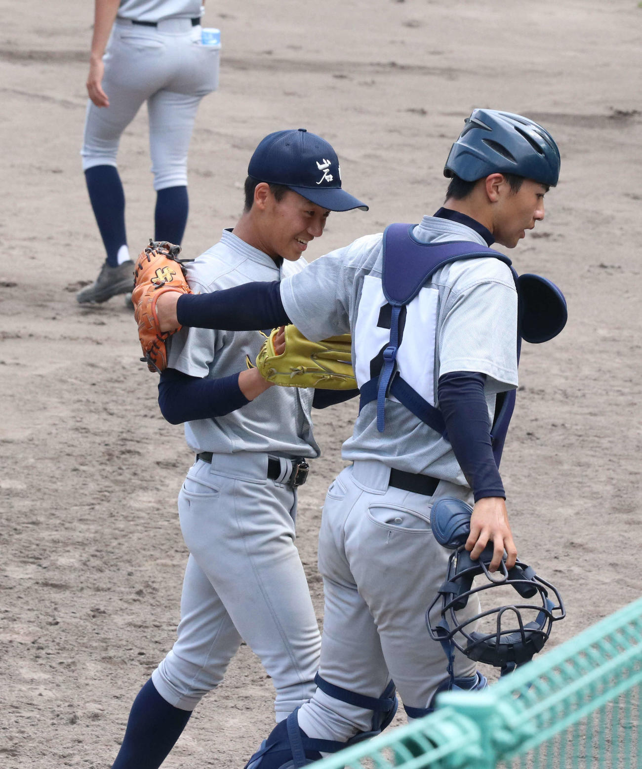 岩内対北照　8回、味方の失策もからんで追加点を許しても笑顔でベンチに引き揚げる岩内先発の松屋（左）。右は捕手の中西主将（撮影・浅水友輝）