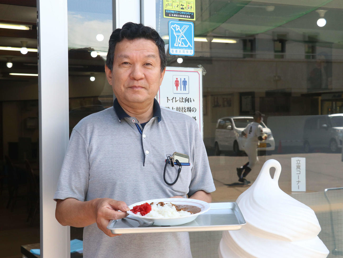 看板商品の「円山カレー」を手にする円山球場食堂店長の井上さん（撮影・浅水友輝）