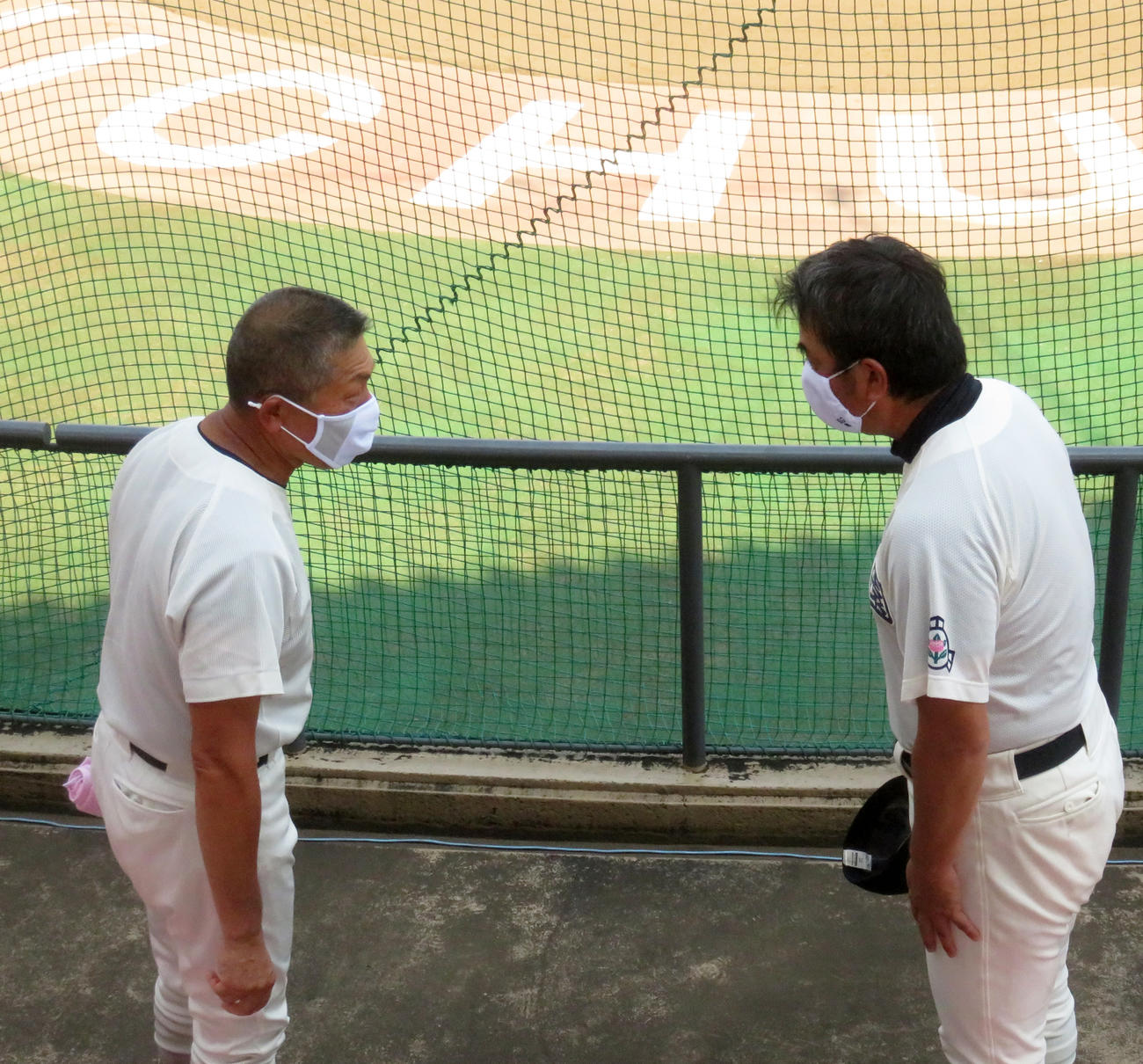 試合後、日大三・小倉監督（左）から祝福され恐縮する佼成学園・藤田監督（撮影・玉置肇）