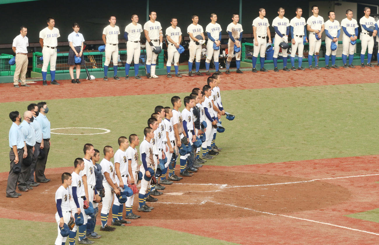 磐城対聖光学院　2－4で敗れ、無念の表情でベンチ前に並ぶ磐城の選手たち。手前は校歌を聞く聖光学院の選手たち（撮影・野上伸悟）