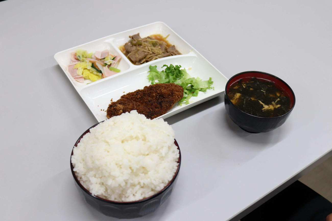 水戸啓明の寮の夕飯。トンカツ、豚肉の中華炒め、ハムとキャベツのサラダ、タマゴとワカメのスープ、1キロご飯（撮影・沢田直人）