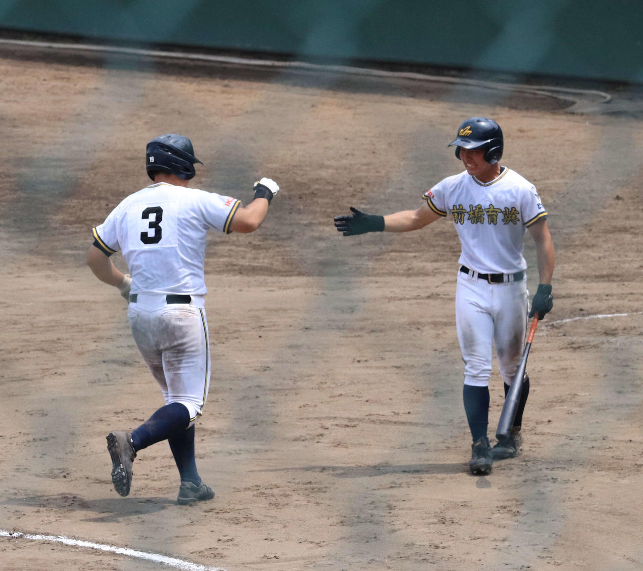 伊勢崎清明対前橋育英　7回裏前橋育英2死一塁、初球を左翼スタンドに運ぶ起死回生の逆転ツーラン本塁打を放ち、チームメートとハイタッチで喜ぶ諸田（左）（撮影・小早川宗一郎）