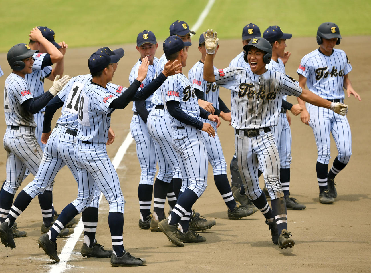 佼成学園対東海大菅生　10回裏東海大菅生1死二塁、サヨナラとなる左中間への適時打を放ちナインとタッチをかわす堀町（前列右）（撮影・横山健太）