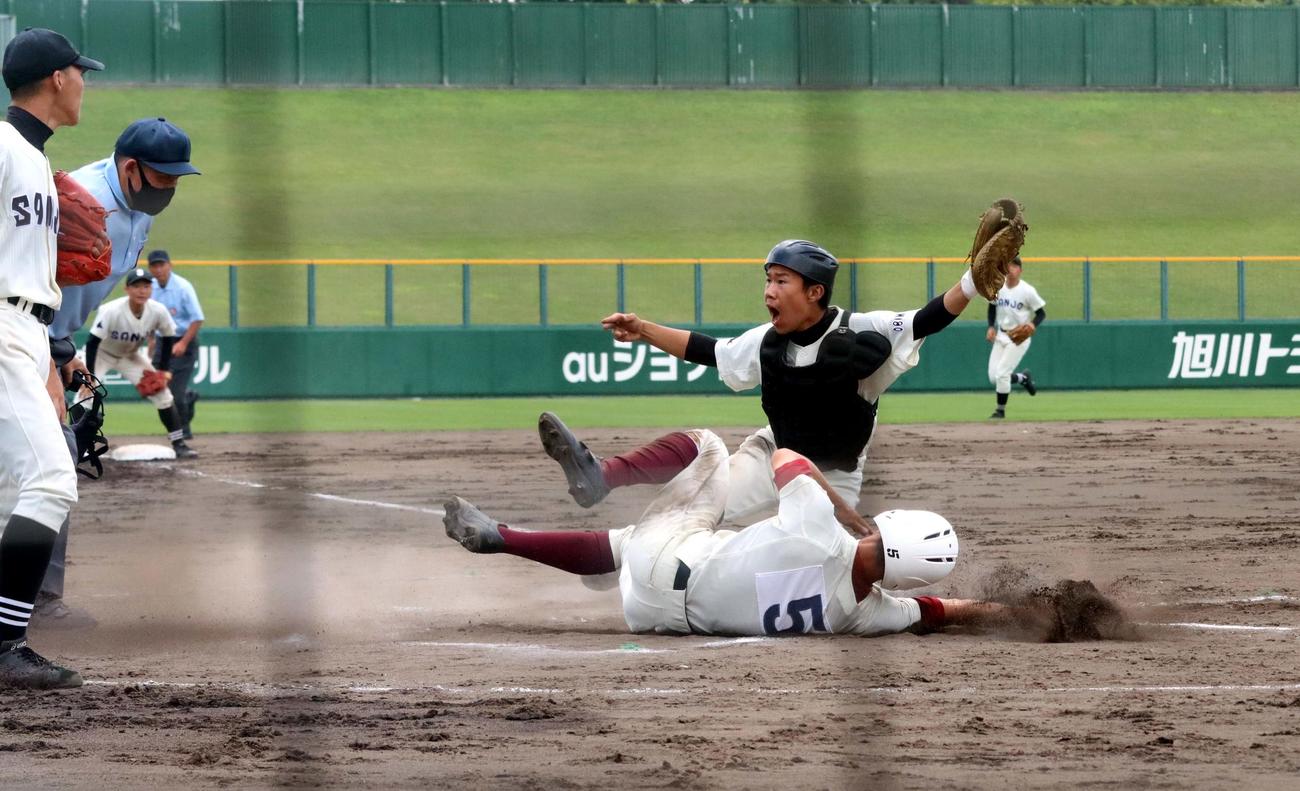 旭川大高対帯広三条　6回表旭川大高1死二、三塁、小田左翼手の左飛で三塁走者の栗谷川（手前）が本塁へ突入も、好返球で、帯広三条・棚田捕手（右）にタッチされアウトになる（撮影・永野高輔）