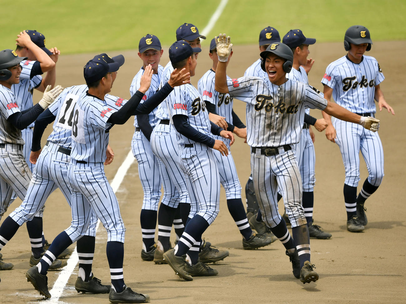 10回裏東海大菅生1死二塁、サヨナラとなる左中間への適時二塁打を放ちナインとタッチをかわす堀町（前列右）（撮影・横山健太）