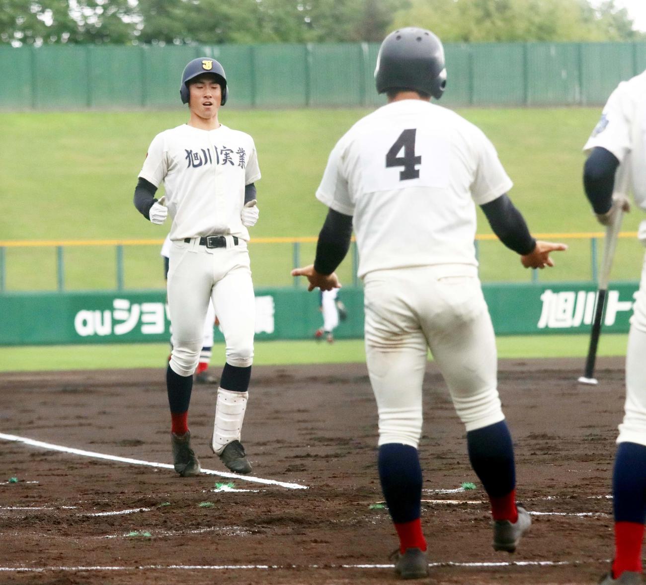 釧路湖陵対旭川実　1回裏旭川実2死一、三塁、大井（左）が左越え3ランを放ち生還する（撮影・永野高輔）