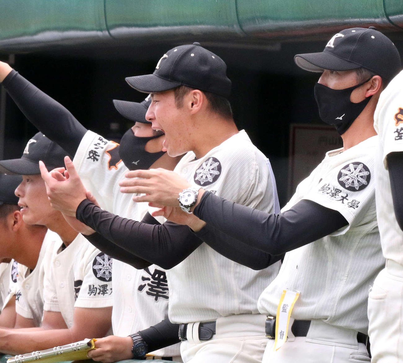 9回裏の攻撃中にベンチから声援を送る駒大苫小牧の北嶋（左）。右は佐々木監督（撮影・浅水友輝）
