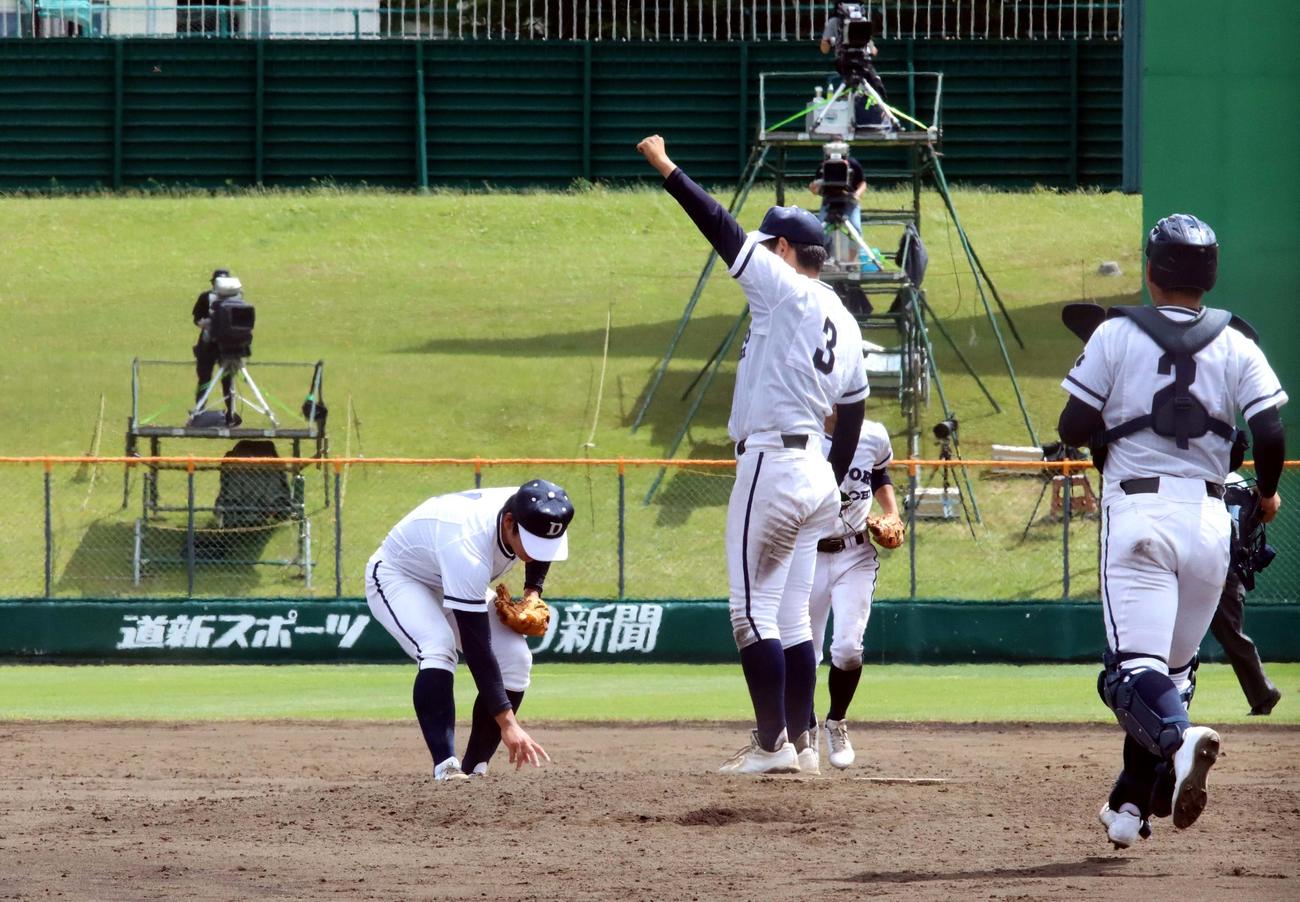 札幌第一対札幌国際情報　優勝の瞬間、左手を挙げてマウンドに駆け寄った西正の前で、冷静にロジンバックを拾う札幌第一エース山田（撮影・永野高輔）