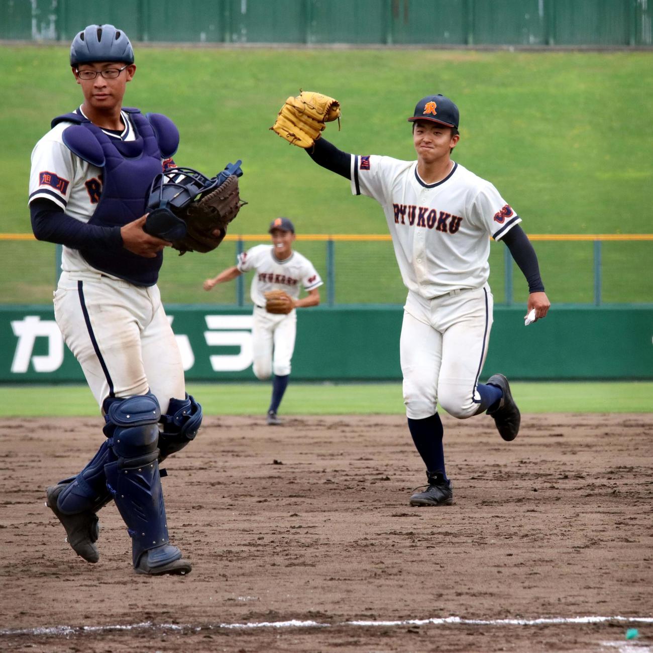 旭川龍谷対旭川実　決勝進出を決めグラブを掲げ喜ぶ旭川龍谷・長谷（右）。左は斉藤（撮影・永野高輔）