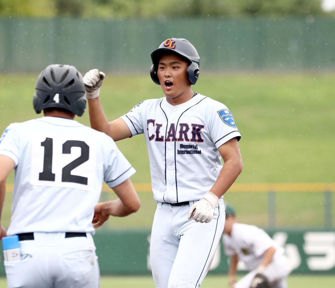 武修館対クラーク　3回裏クラーク1死一、三塁、右前適時打を放ちガッツポーズの佐藤（撮影・黒川智章）