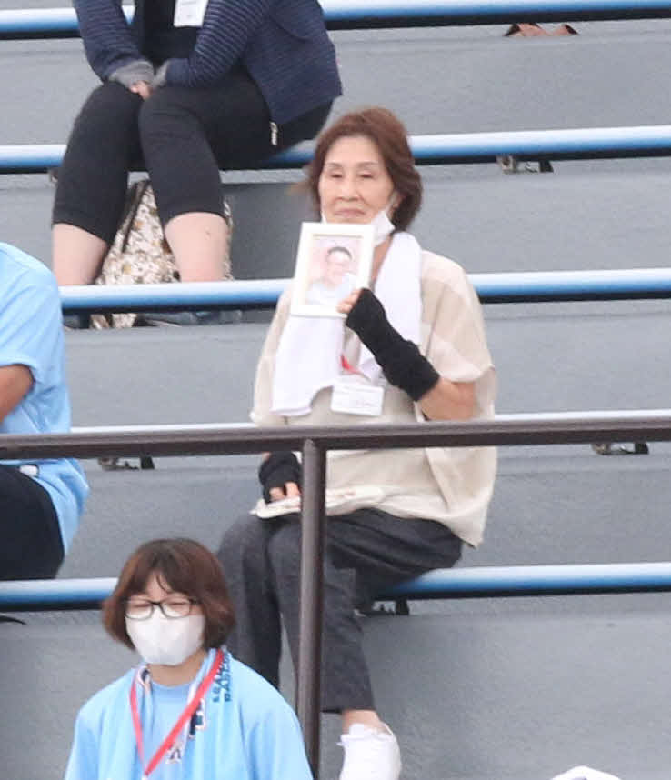 旭川龍谷対クラーク　旭川龍谷・菅が“お兄ちゃん”と慕っていた叔父の故松原貴由さんの遺影を持って応援に駆けつけた祖母松原美恵子さん（撮影・浅水友輝）