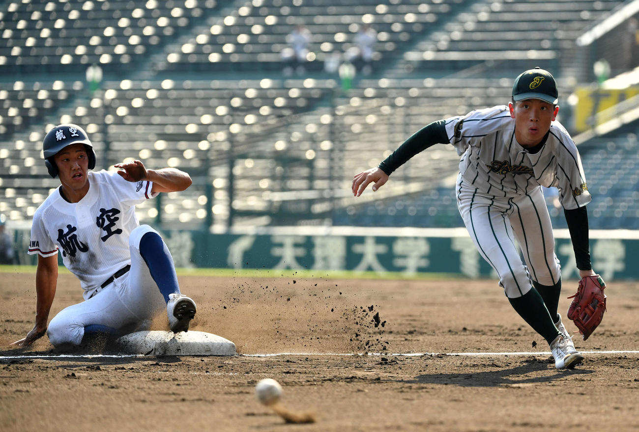 鶴岡東対日本航空石川　2回裏日本航空石川無死一、二塁、暴投により竹下（左）は本塁へ生還する。右は伊藤（撮影・横山健太）