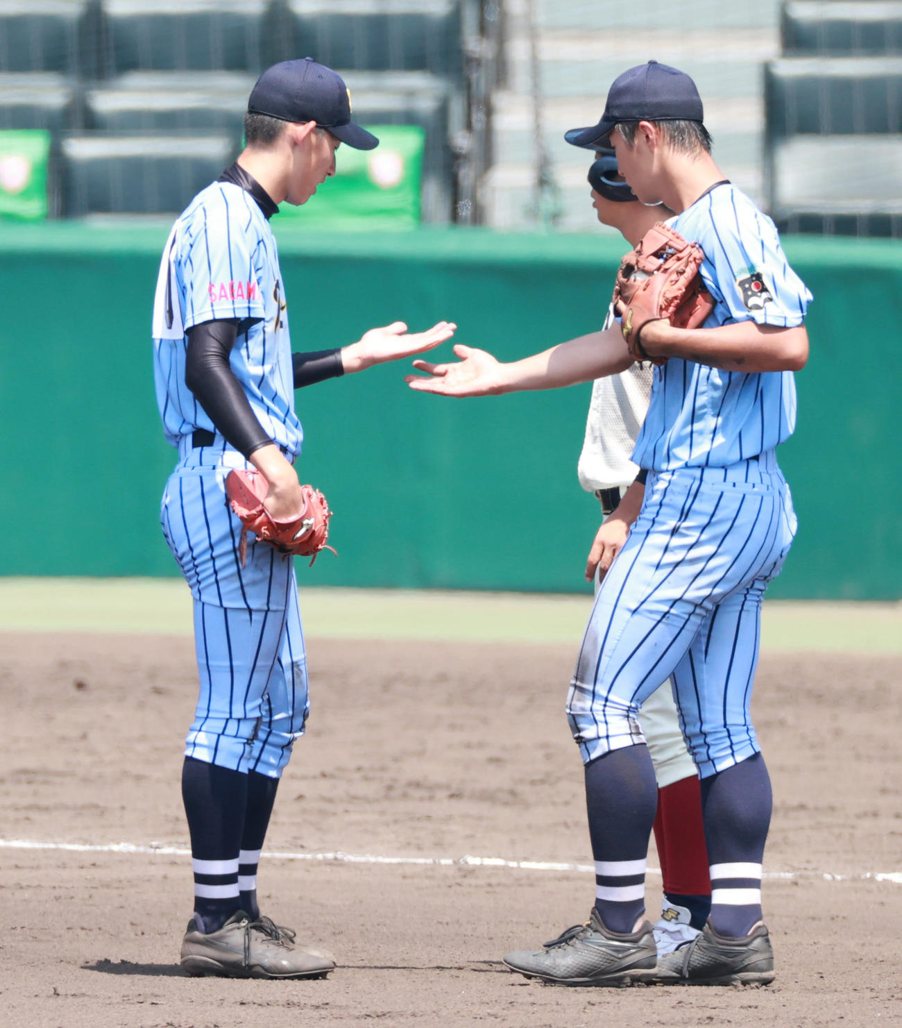 東海大相模対大阪桐蔭　7回裏大阪桐蔭1死一、二塁、池田の投手返しを素手で捕りにいった東海大相模・石田（左）は状態を確認する（撮影・清水貴仁）