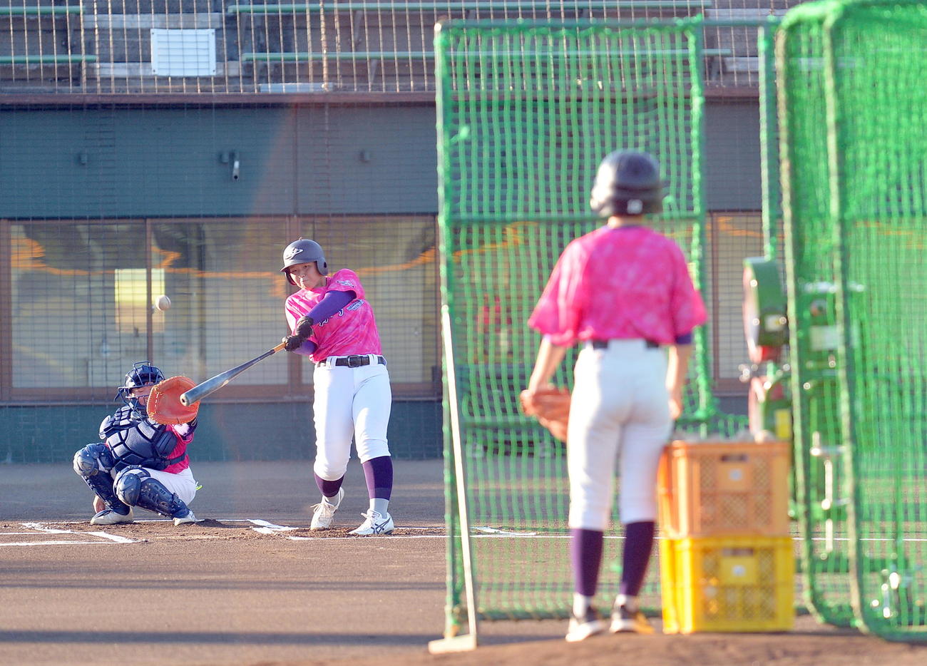 エンゼルス大谷から寄贈された打撃練習用の投球マシンで練習を行う花巻東女子野球部の河野主将（中央）（撮影・鎌田直秀）