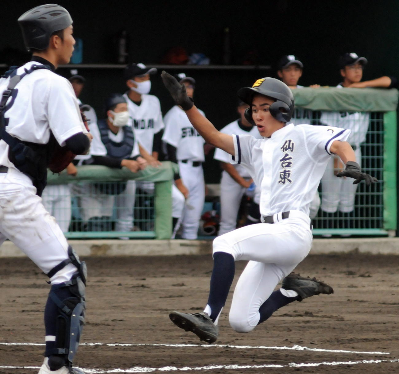 初回、先制のホームを踏む仙台東・高橋主将