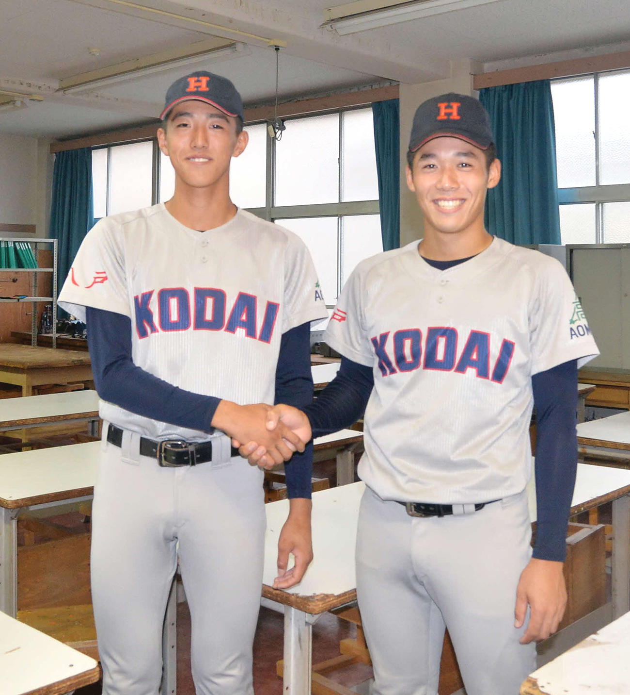笑顔で握手を交わす八戸工大一・黒田（左）と沢口
