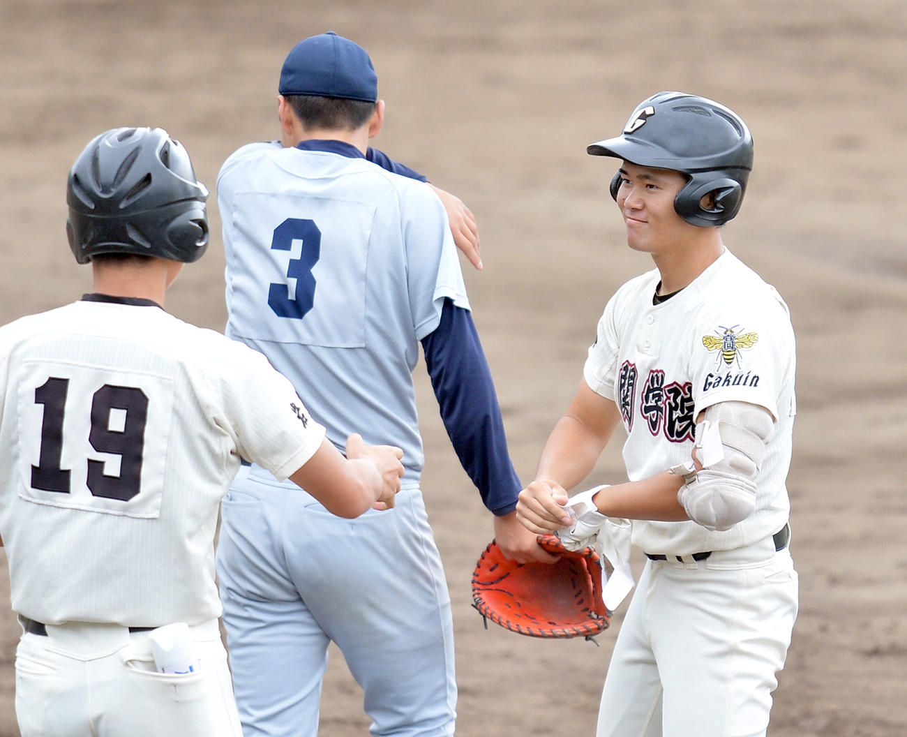 7回表一関学院2死二、三塁、左前2点適時打を放って塁上で笑顔を見せる佐々木（右）（撮影・鎌田直秀）