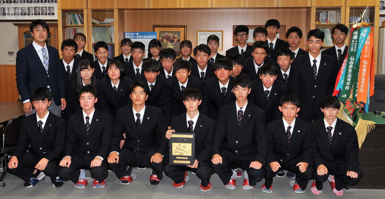 仙台商軟式野球部の選手たちは昨年度獲得した南東北大会最後の優勝旗を手に記念撮影（撮影・佐々木雄高）